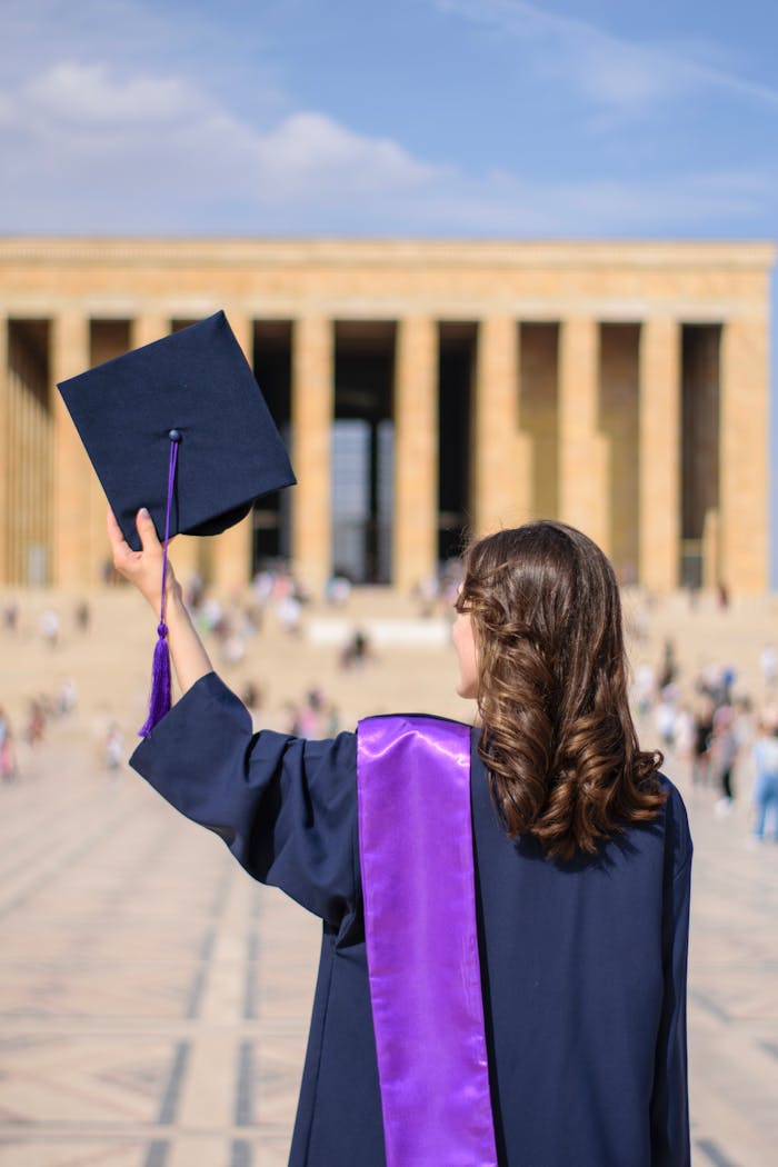 A woman in graduation attire celebrates at Anıtkabir in Ankara.